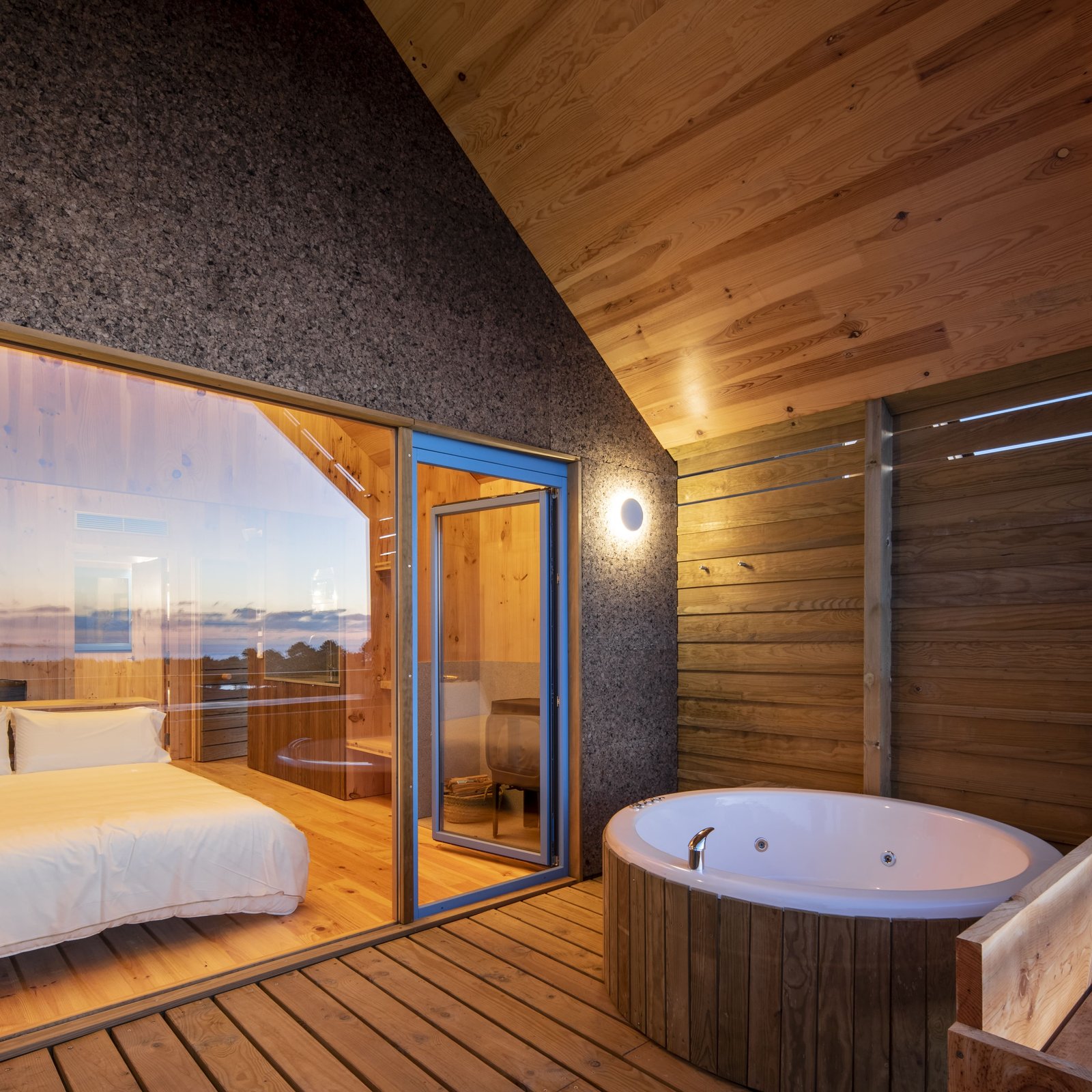Terraza de madera con bañera de hidromasaje junto al dormitorio
